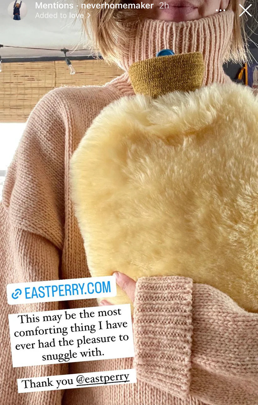 Person holding a sheepskin hot water bottle warmer