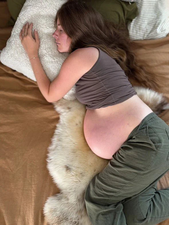 Person lying on ivory shearling sheepskin pillow