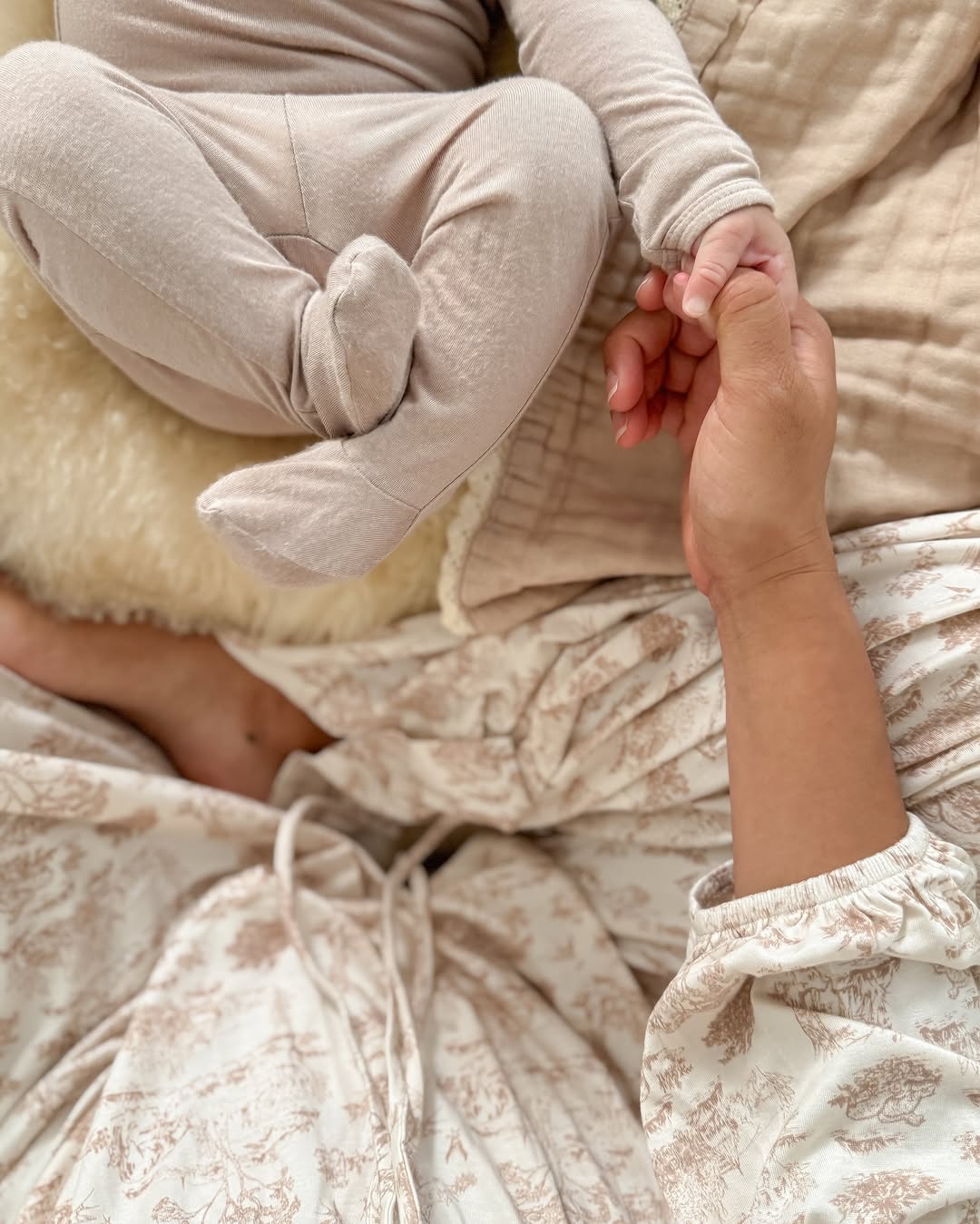 A postpartum mother at home wrapped in natural sheepskin