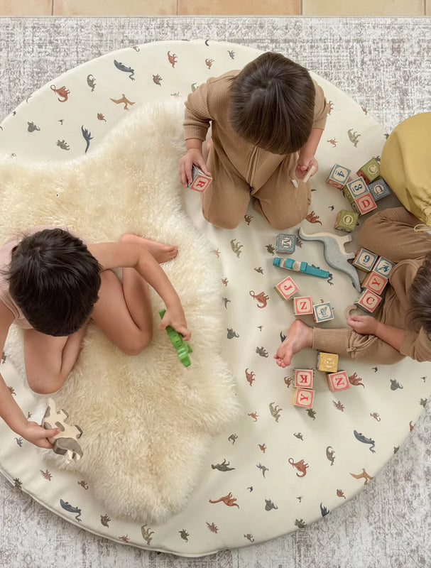 Children playing on a bright ivory nursery sheepskin