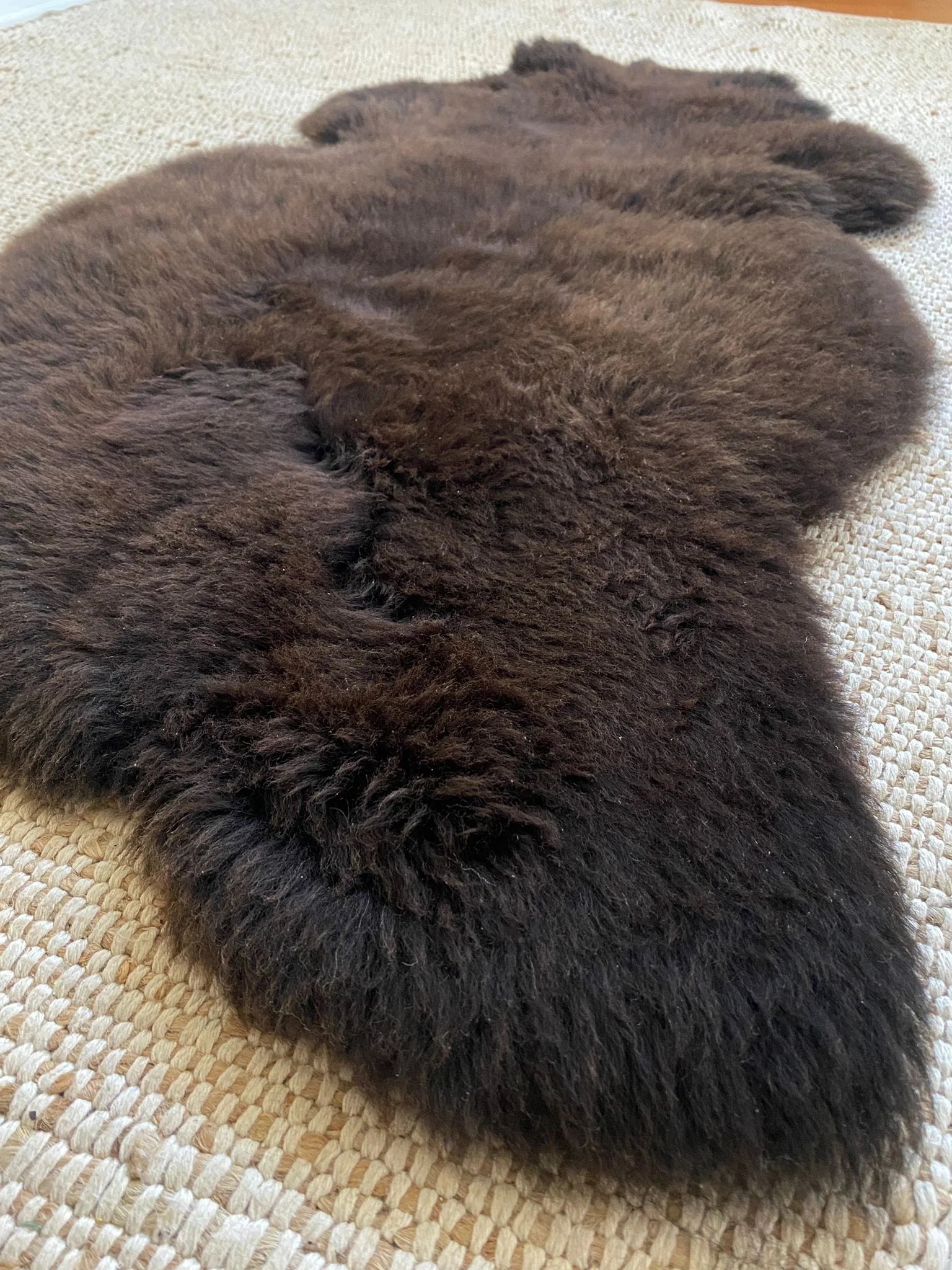 Dark Brown fur rug on a textured surface