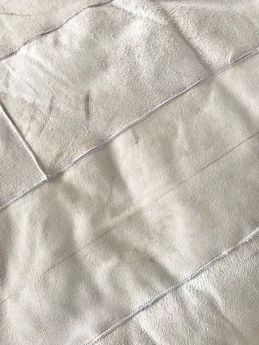Rear-view close-up of creamy ivory sheepskin bed cover rug