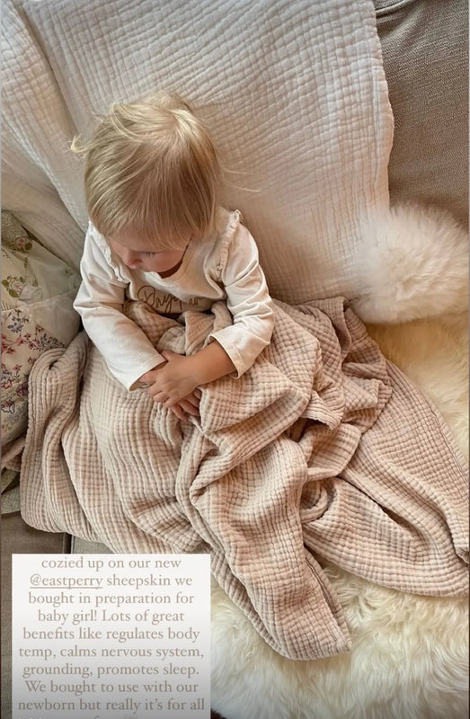 Child sitting on a couch wrapped in a checkered blanket family bundles