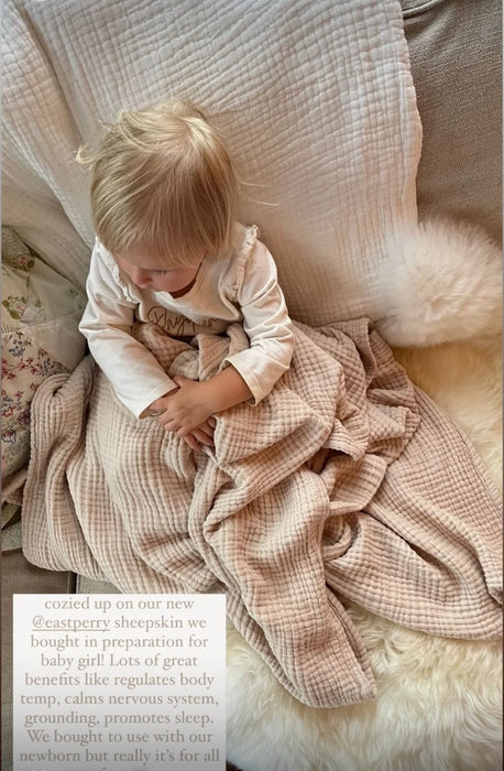 Child sitting on a couch wrapped in a checkered blanket family bundles