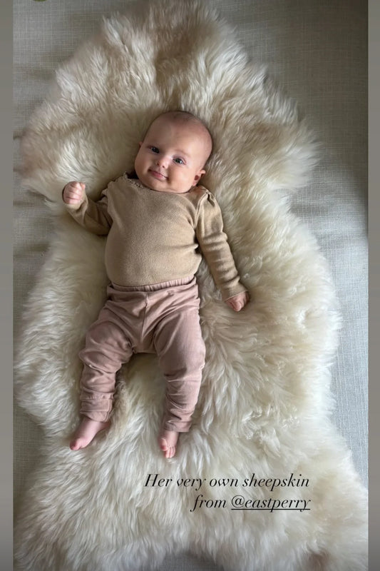 Baby lying on white rug family bundles
