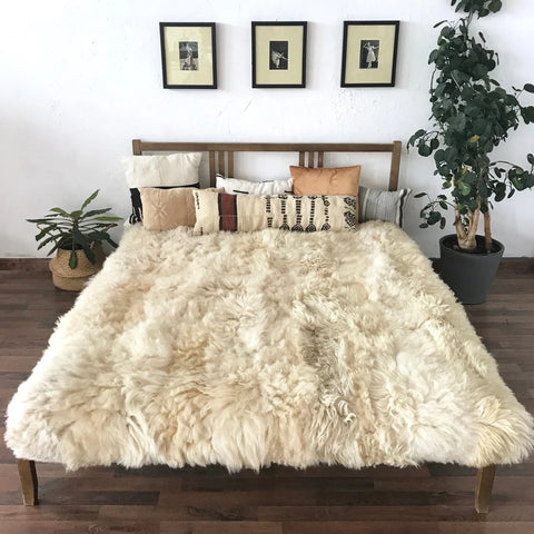 Bed with ivory plush sheepskin blanket