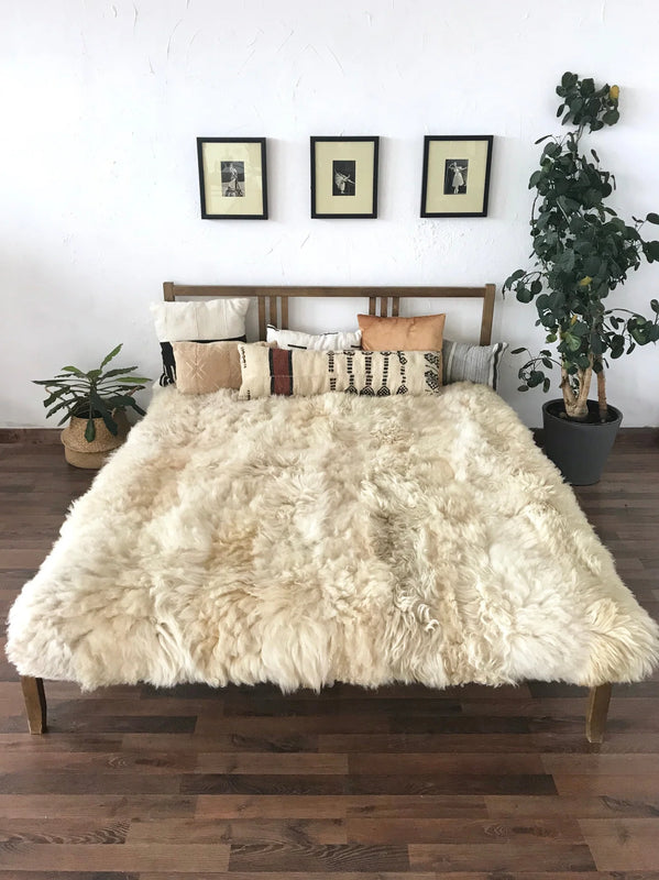 Bed with ivory plush sheepskin blanket