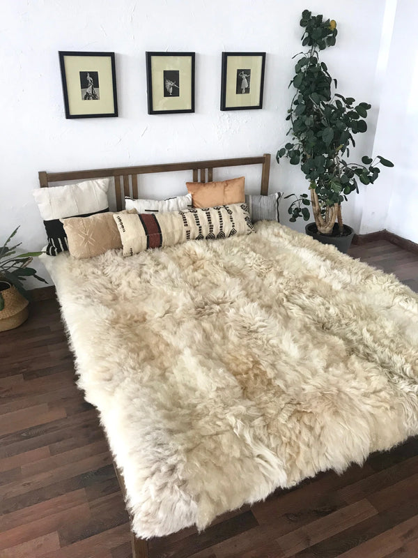 Bed with ivory plush sheepskin blanket