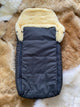baby and toddler sleeping bag with cream sheepskin lining placed on a fluffy rug