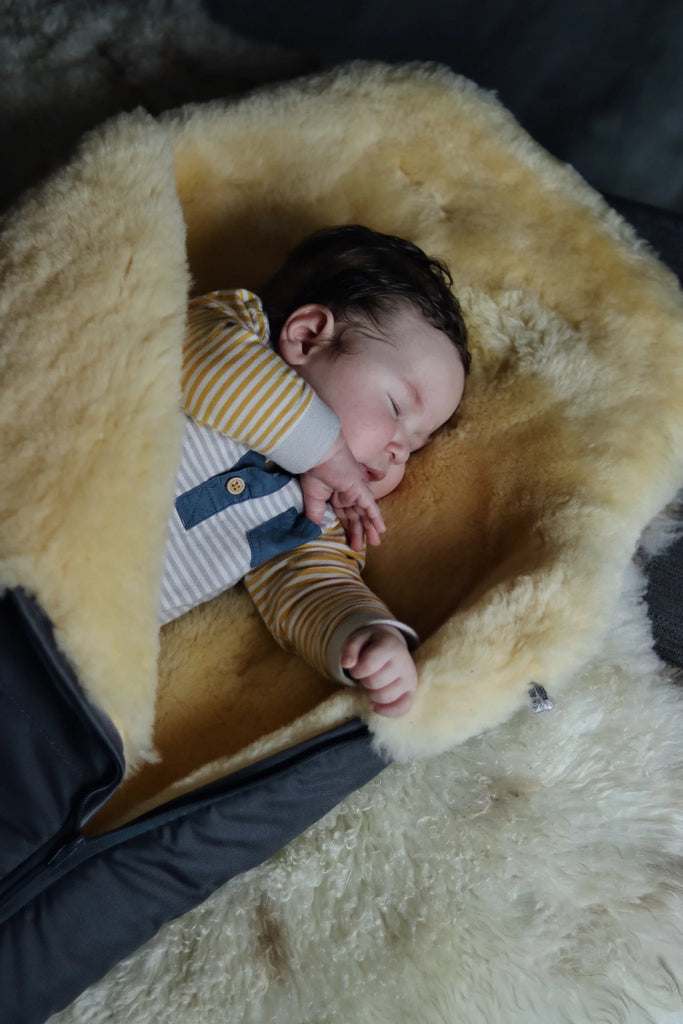 Newborn baby sleeping in a medical sheepskin baby toddler sleeping bag