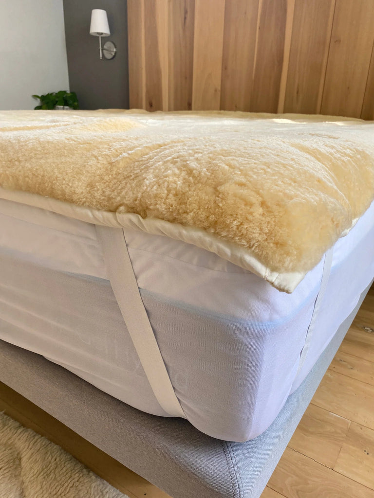 medical sheepskin crib topper on a bed 