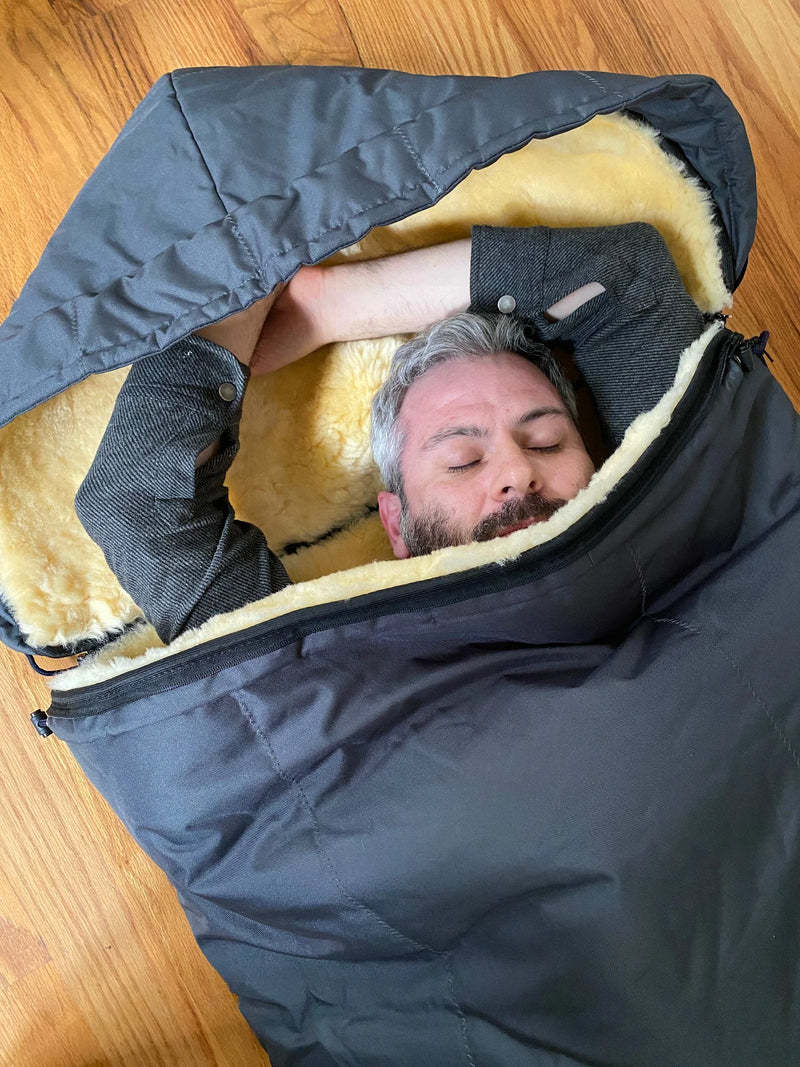 Person lying inside a sheepskin sleeping bag