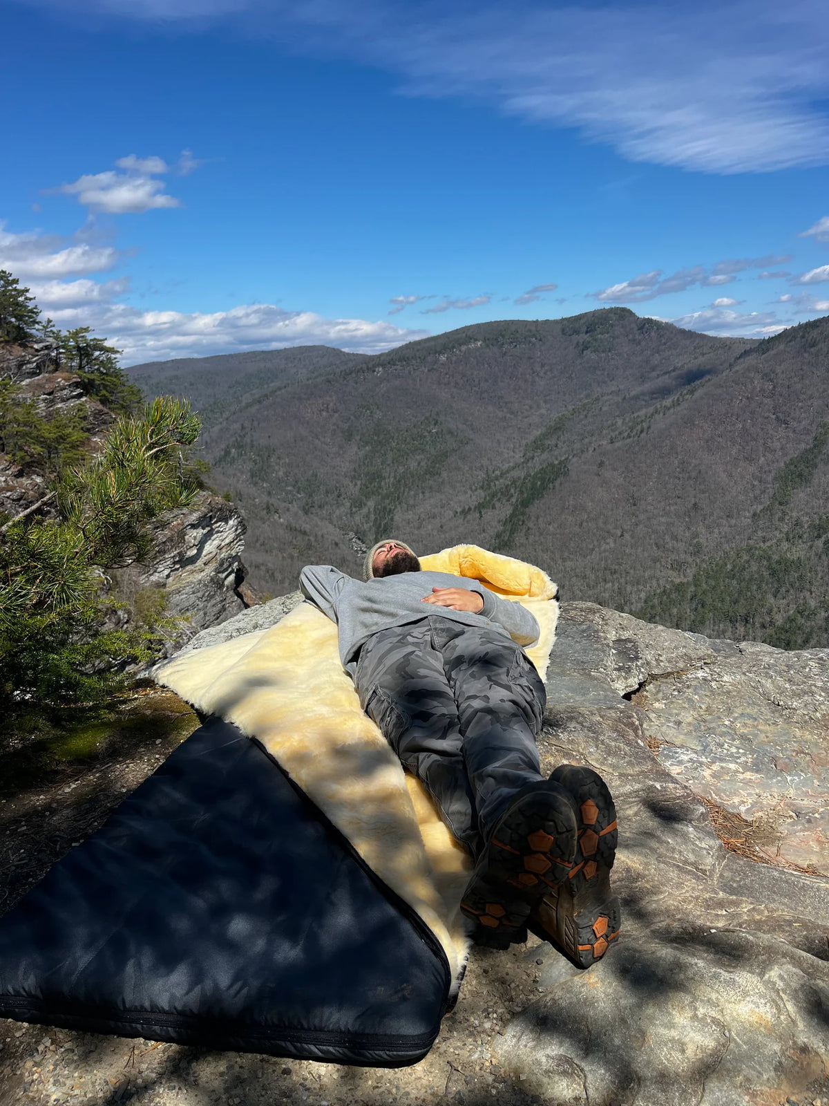 Person lying on a sheepskin sleeping bag