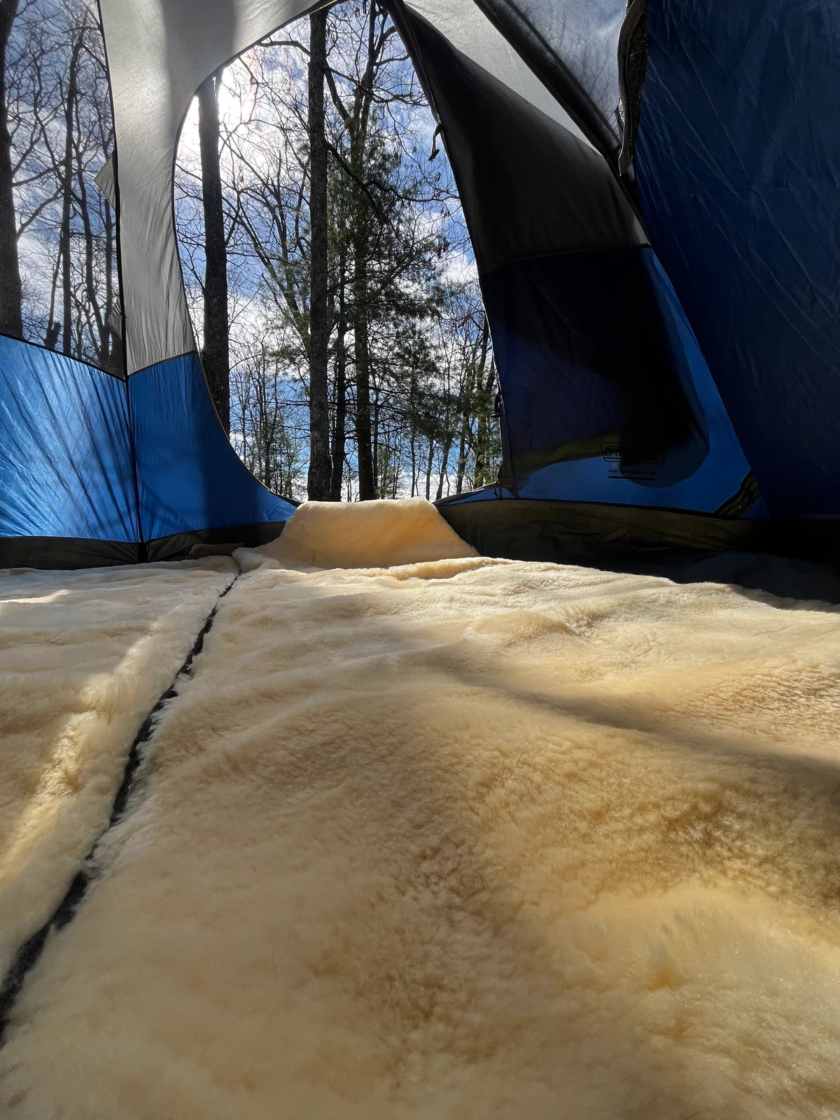 Close-up of a tent interior with sheepskin sleeping bag