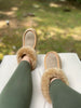 Person wearing brown sheepskin slippers 