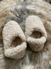 Pair of the everyday slip on tan shearling sheepskin on a fur surface