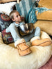 Child wearing brown slippers sitting on the snugly